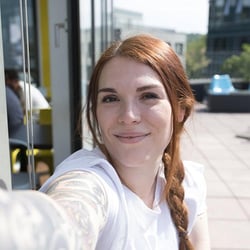 Vrouwelijke Trusted Shops-medewerker lacht voor een selfie.