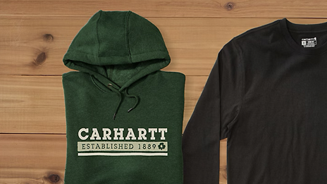 Foto van twee truien. Een is zwart zonder tekst, de andere donker groen met erop de tekst: Carhartt. Established 1889