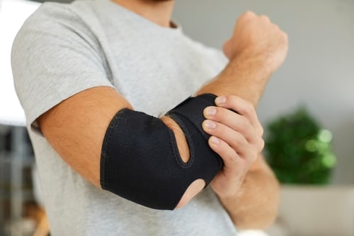 Een man draagt een verband om zijn elleboog.