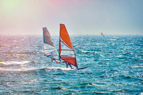 Twee windsurfers op open zee.