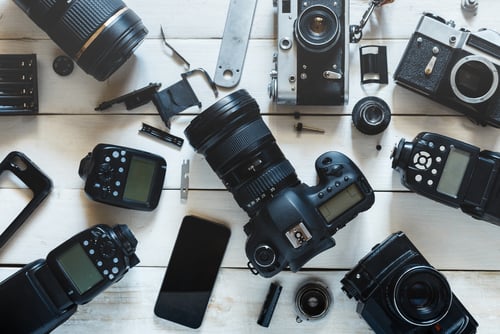 Vintage filmcamera, digitale camera en smartphone op witte houten achtergrond Concept voor technologische ontwikkeling. Bovenaanzicht